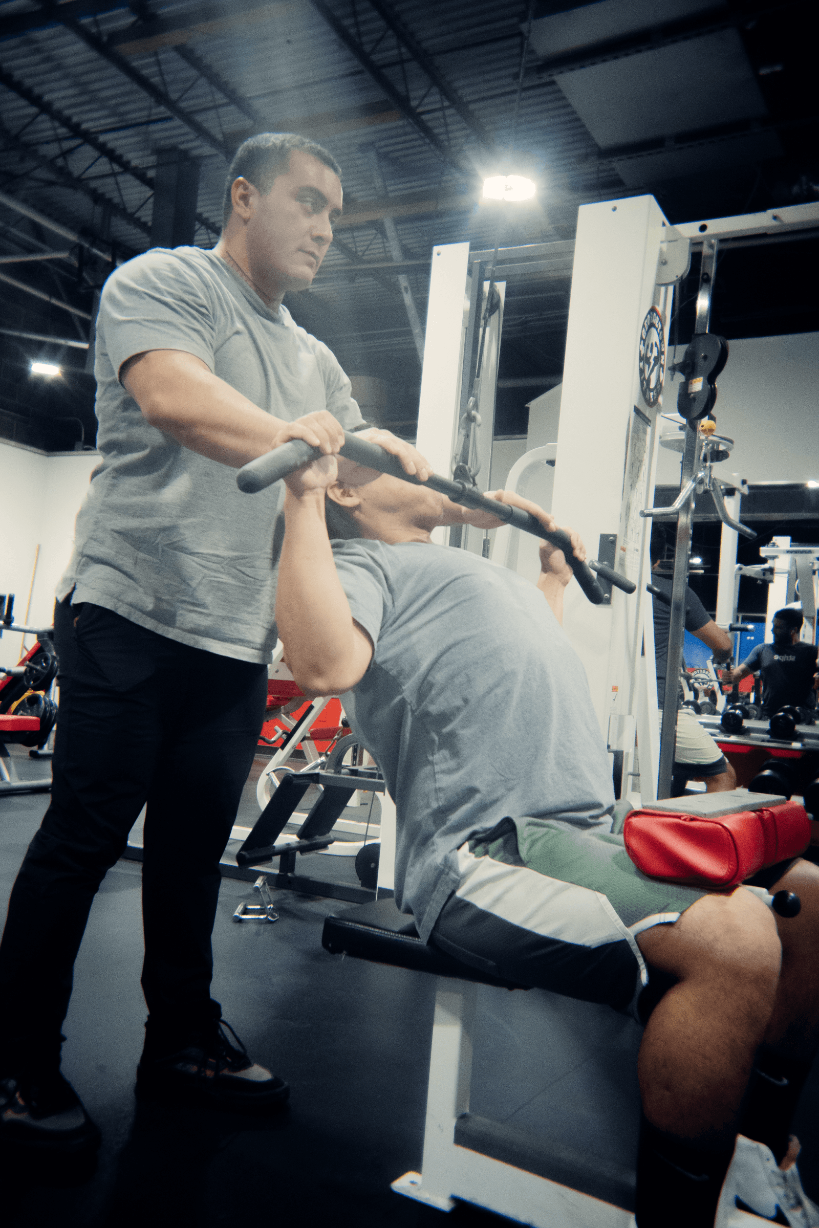 Trainer spotting a seated cable movement at Georgetown Fitness